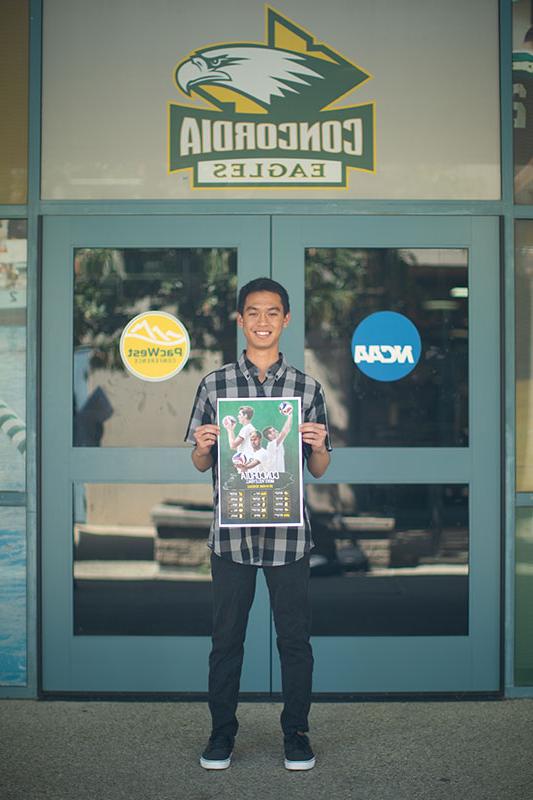 Troy Makalena holding a poster that he designed